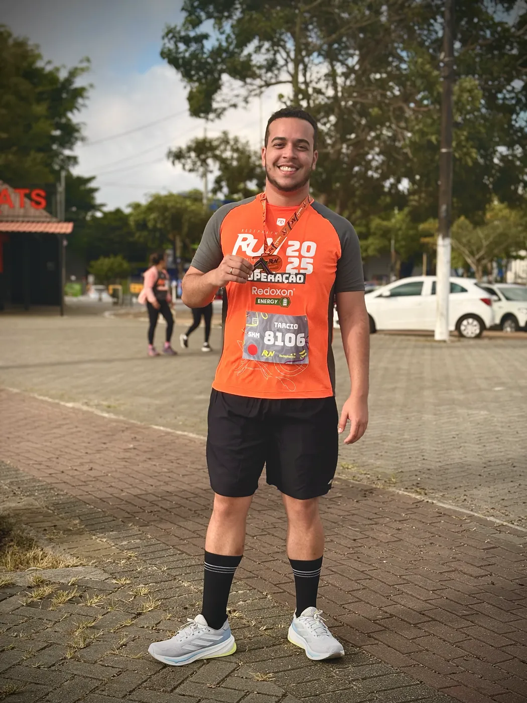 Tarcio com a camisa e a medalha de uma corrida de 2025